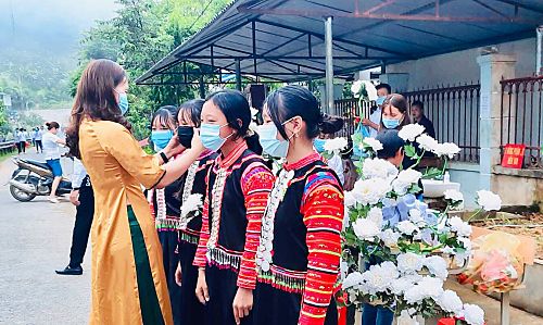 Giáo viên Trường Phổ thông Dân tộc bán trú Tiểu học và THCS Kan Hồ  hướng dẫn học sinh đeo khẩu trang đúng cách.  Ảnh: Hà Dũng